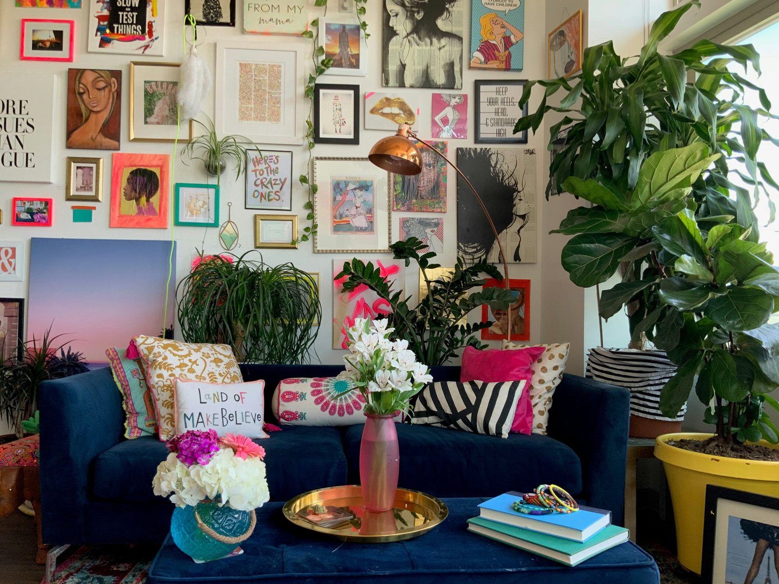 a living room with a blue couch and a vase with flowers